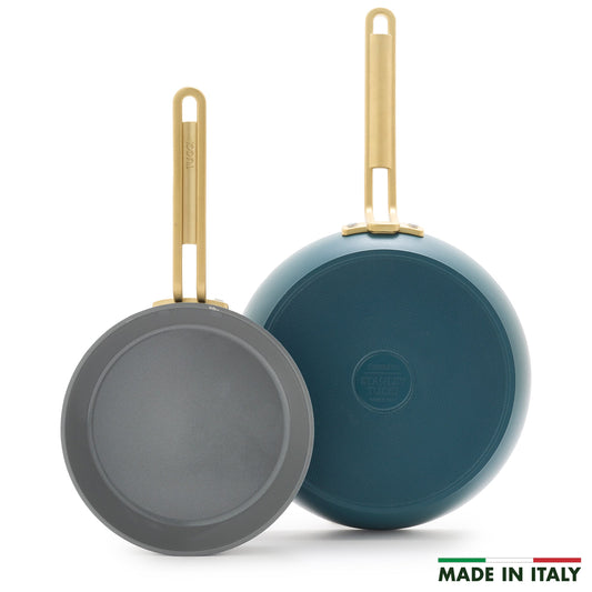 Two Stanley Tucci™ Ceramic Nonstick frypans (20cm & 26cm) with gold handles—one displaying the cooking surface, the other its Venetian Teal bottom. PFAS-free and MADE IN ITALY text with Italian flag appear at lower right.