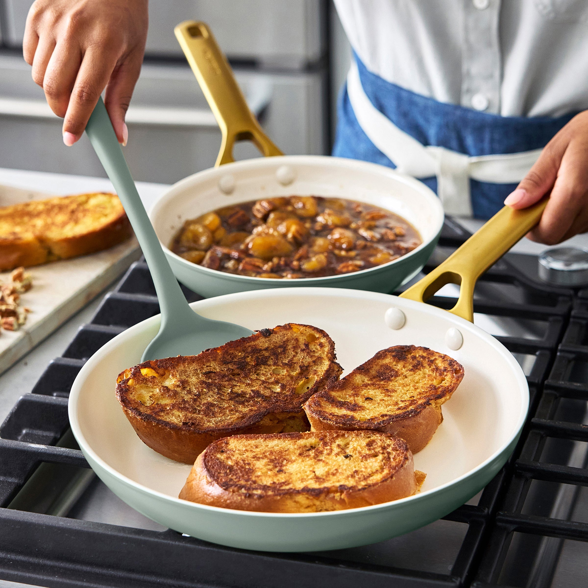Person cooking French toast in a green frypan on a stove