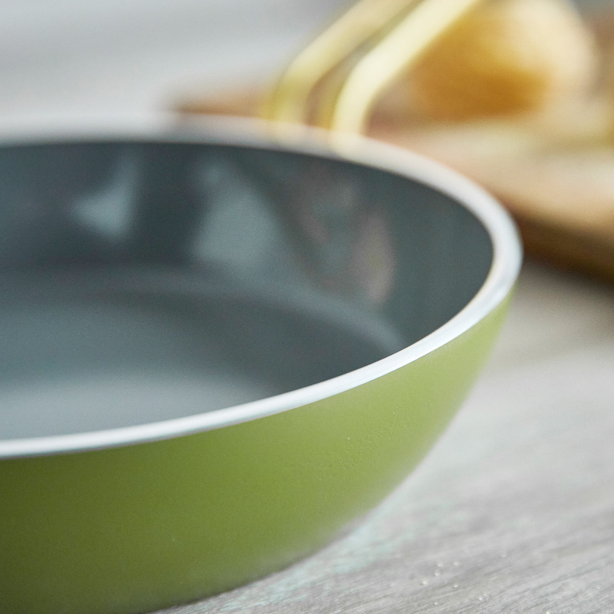 Green frypan on a wooden surface