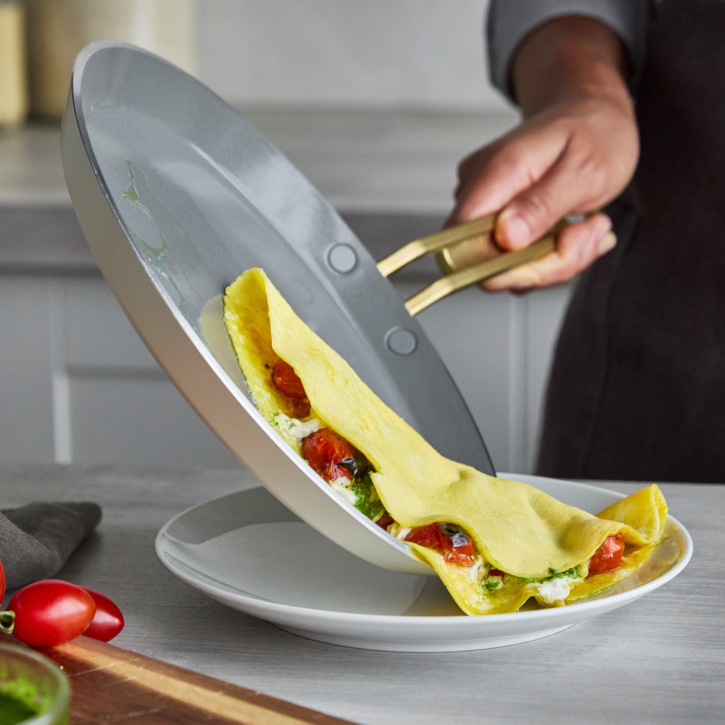 Crepe being released from a crepe pan onto a white plate