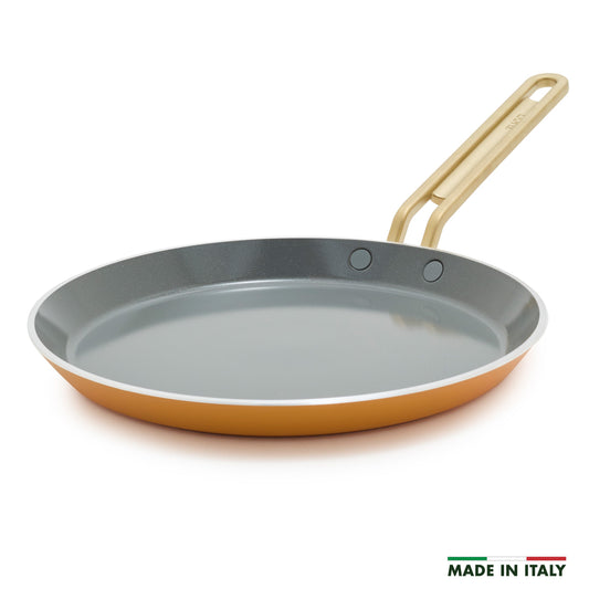 Yellow crepe pan with a gold handle on a white background